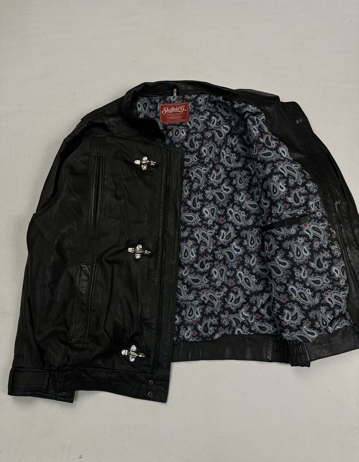 Vintage jacket held open to show the paisley lining running across the whole body