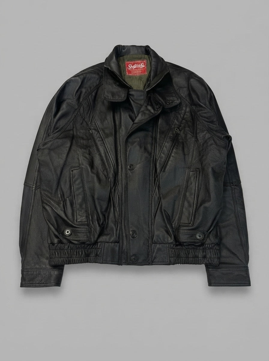 Black leather vintage jacket, size L, shown flat from the front. Wide collar and four snap pockets.