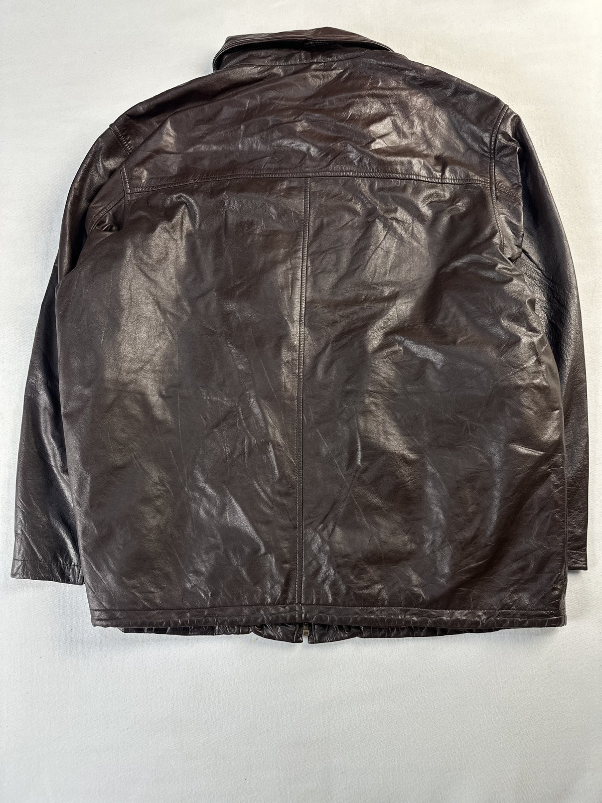 Back of the XL brown jacket laid flat showing the glossy leather panel and centre seam
