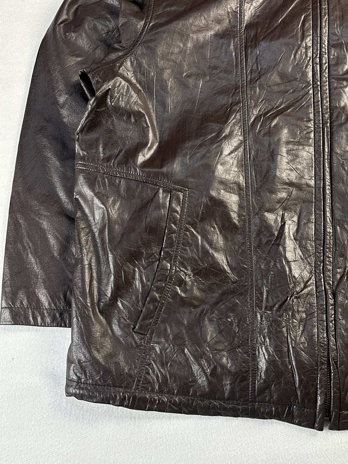 Lower left front with a slash hand pocket and the straight stitched hem