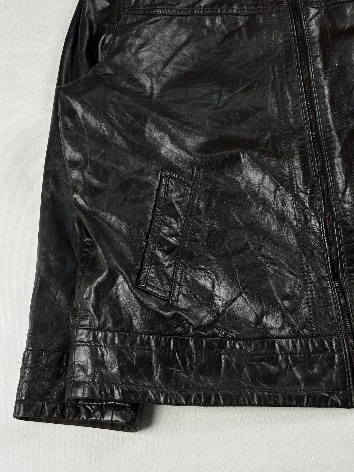 Angled view of a front pocket, the cuff and the stitched hem band on the brown leather