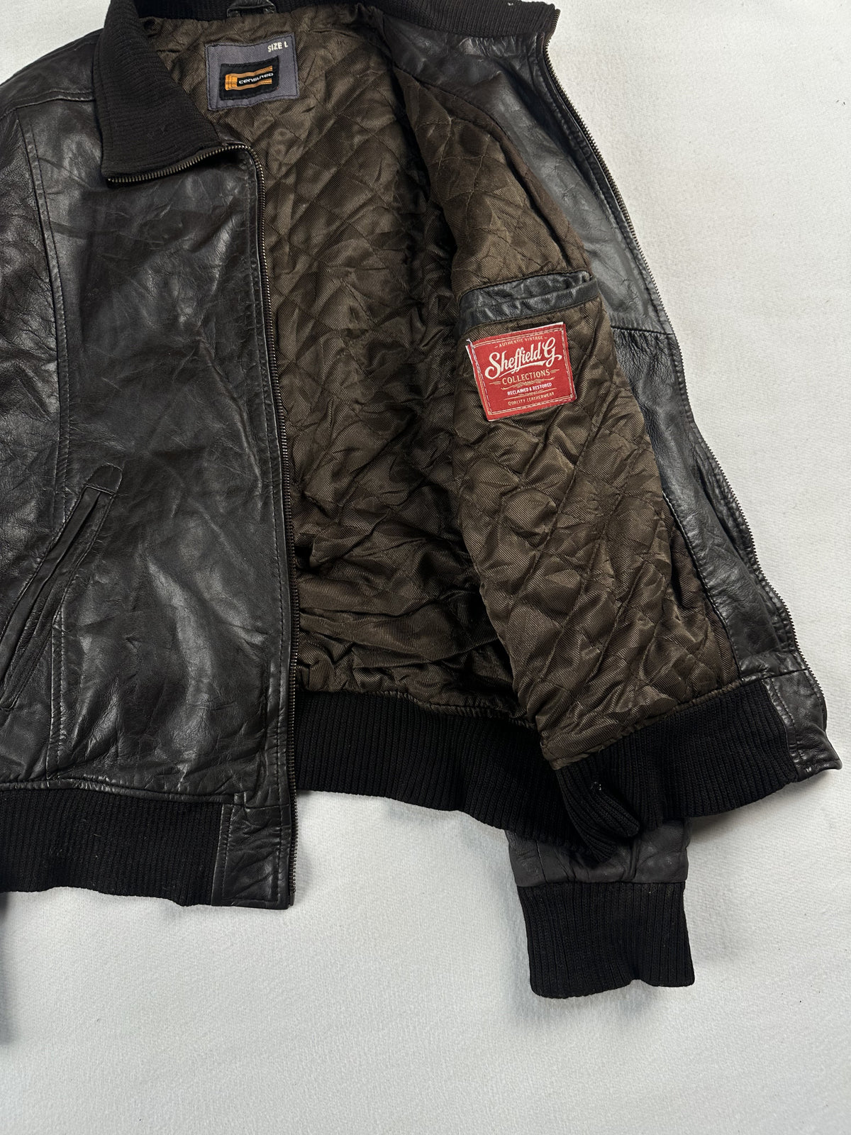 Brown flight jacket opened out to show the quilted interior and ribbed collar