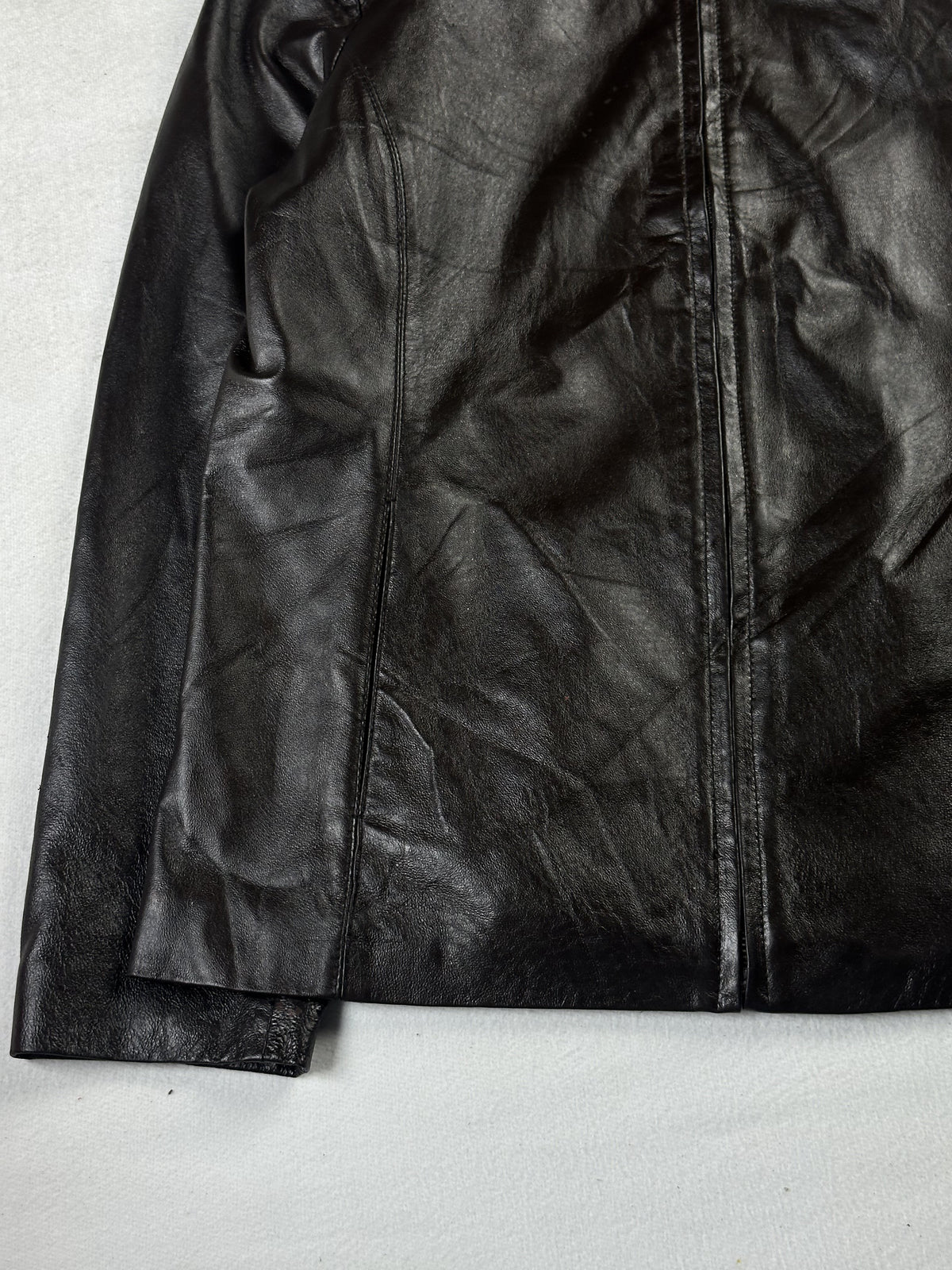 Side seam pocket on the left front, above the plain leather hem and cuff