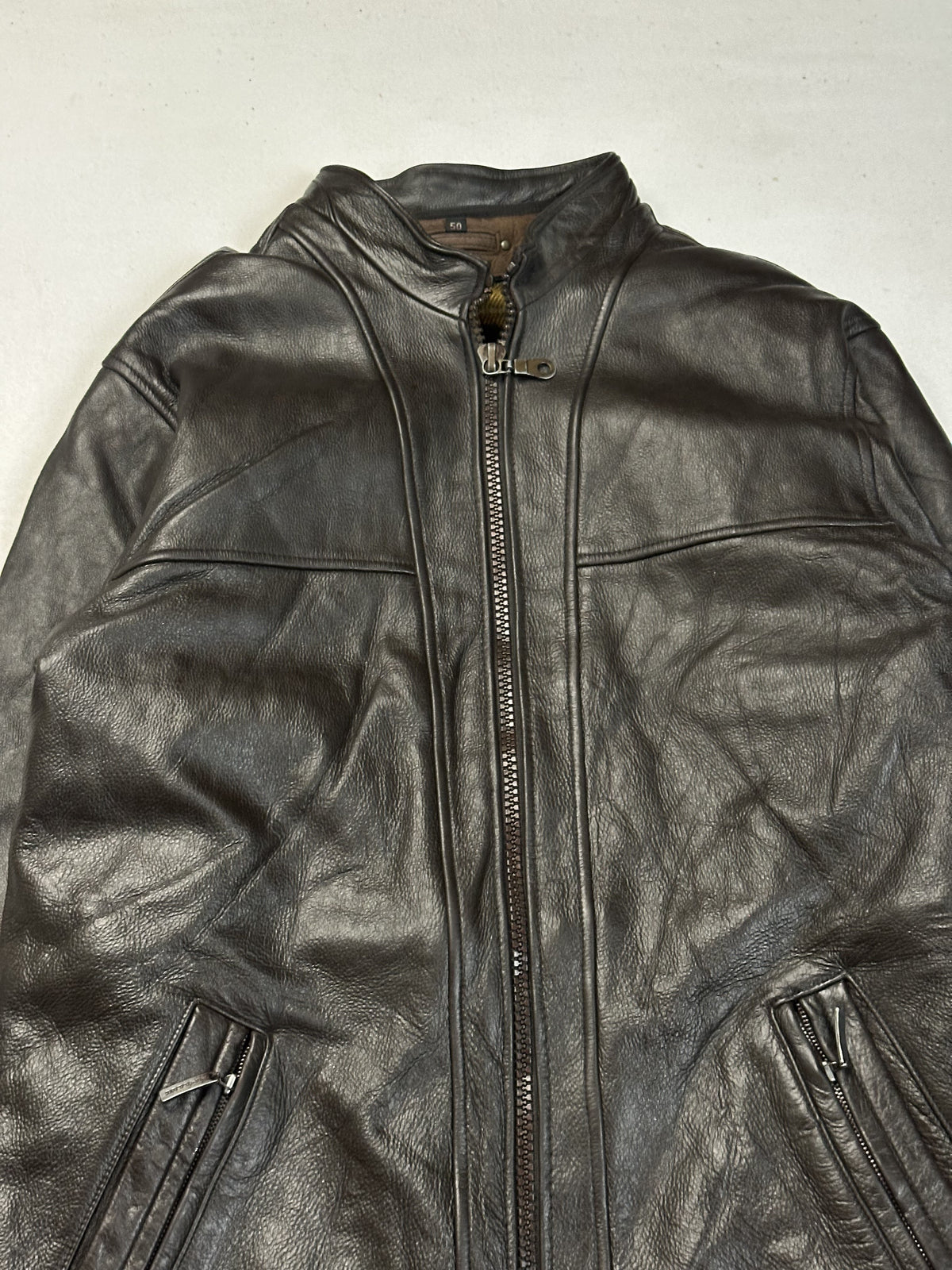 Upper front and band collar of the brown leather cafe racer jacket seen close up