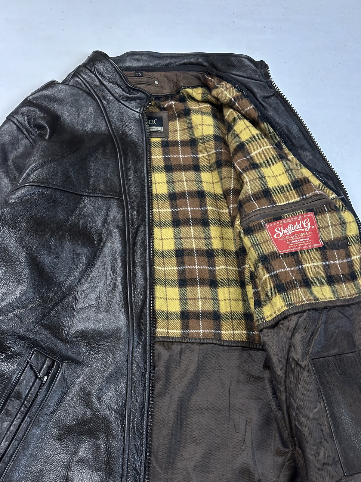 Close view of the yellow and brown tartan lining inside the size L cafe racer jacket