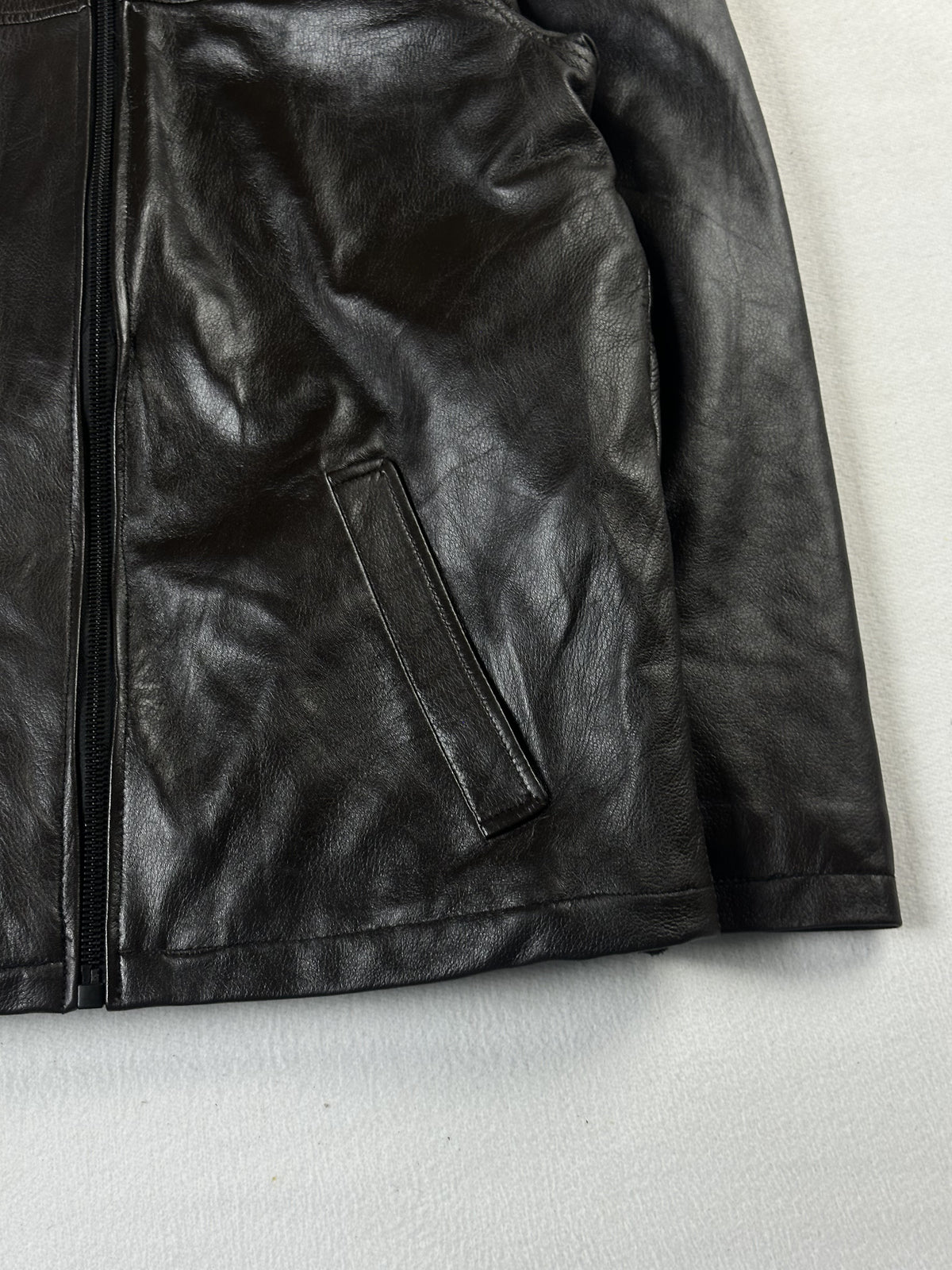 Detail of the right welt pocket and the straight hem beside the cuff
