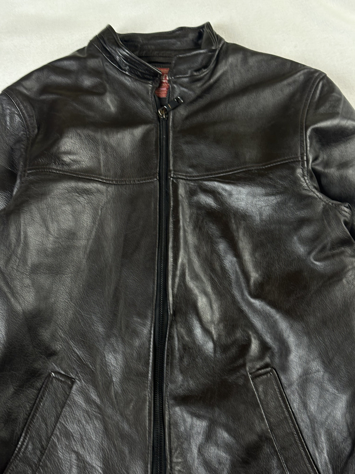 Close view of the snap-tab band collar and the central zip running down the front