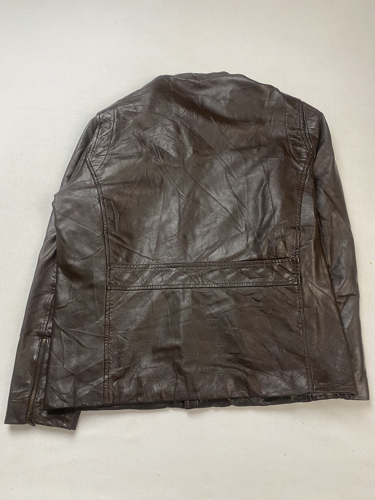 Rear view of the XL brown cafe racer laid flat with a seam across the lower back