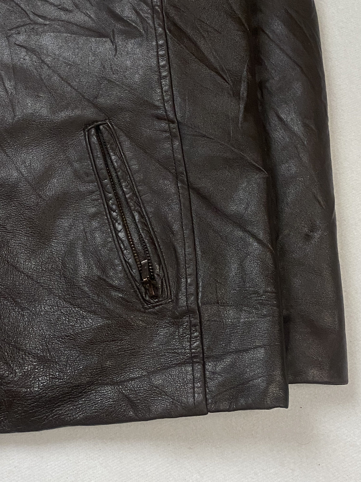 Close look at the right hand pocket zip and the hem of the brown leather jacket