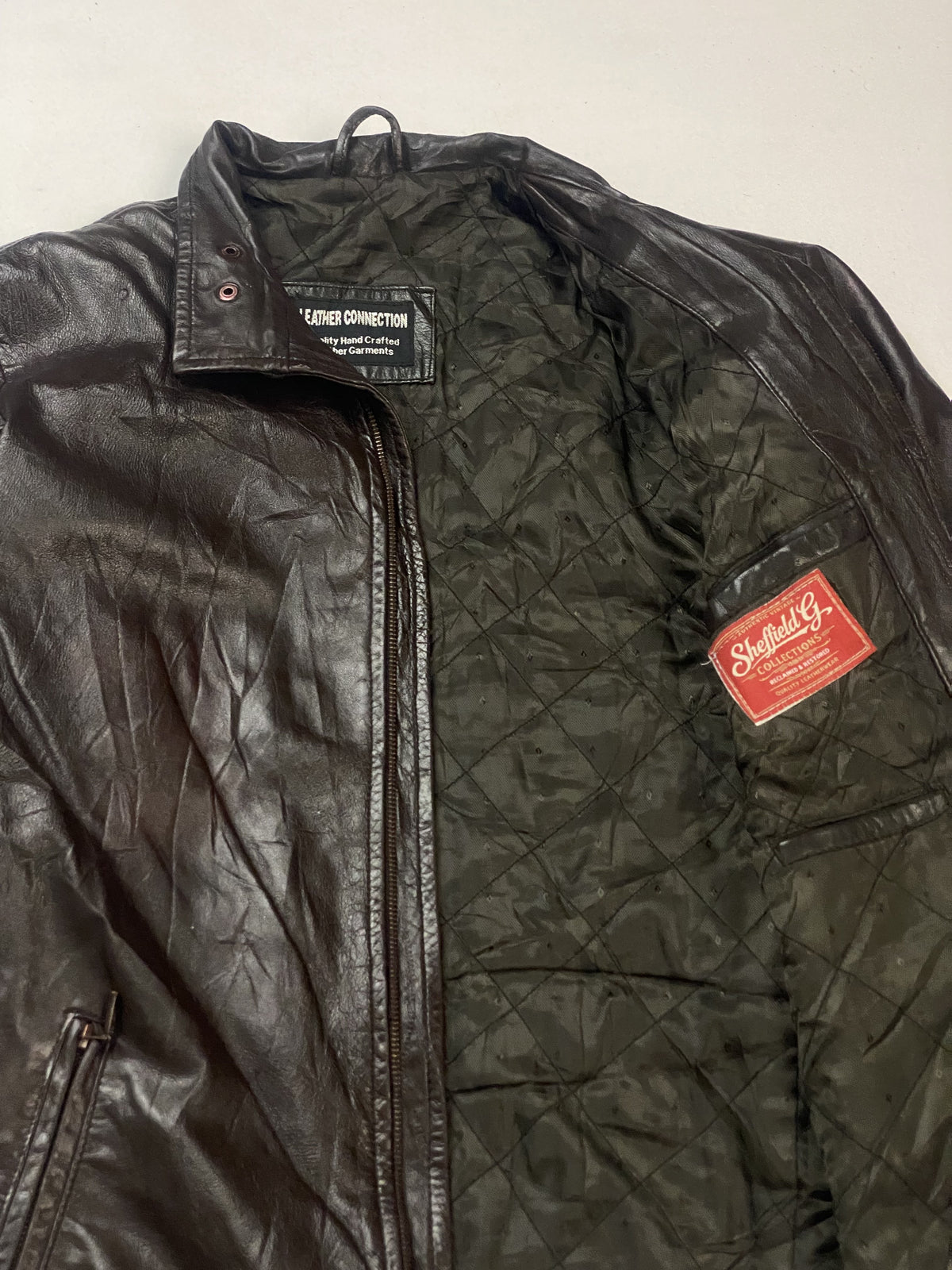 Detail of the diamond-quilted olive lining and the stitched inner labels