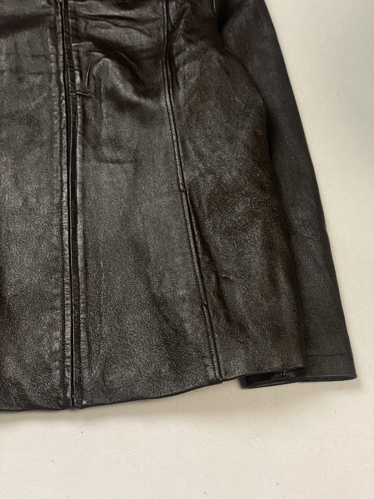 Hem and sleeve cuff at the lower right of this vintage brown leather jacket