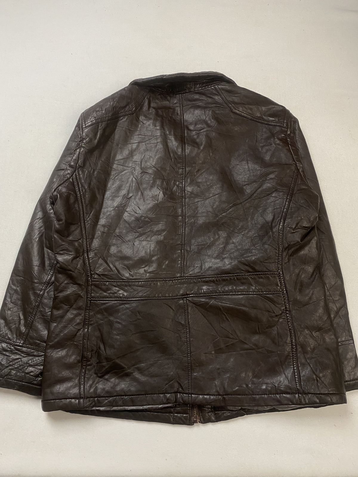 Diamond quilting across the brown leather of the jacket