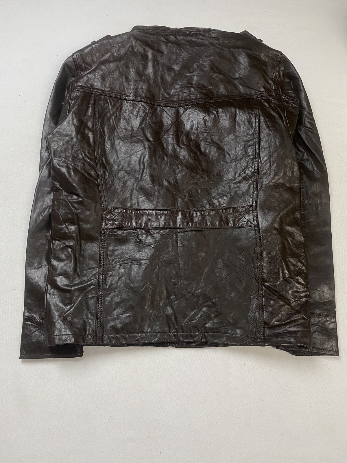 Back of the L brown field jacket laid flat showing the seamed leather panel