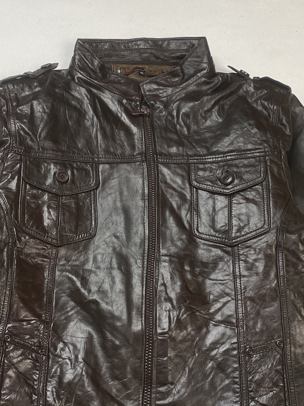 Snap-tab collar fastening at the neck above the studded chest pockets