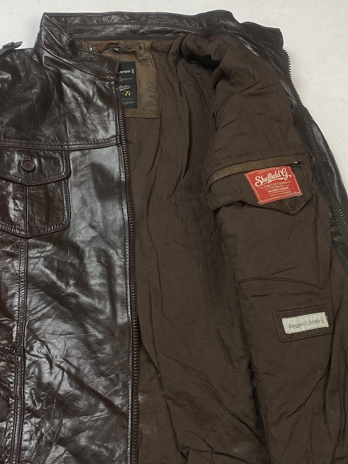 Close view of the brown lining and stitched inner labels inside the jacket