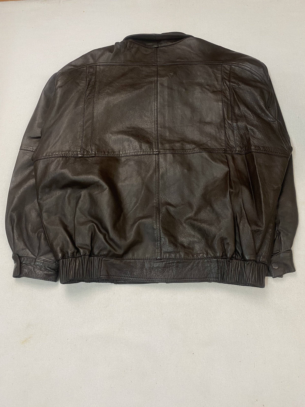 Metal clasp fastening on the brown leather harrington