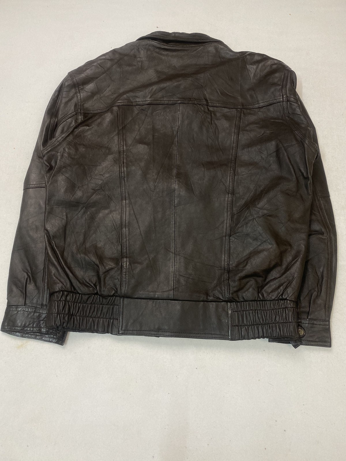 Back of the L brown leather jacket showing the plain panel and elasticated waistband