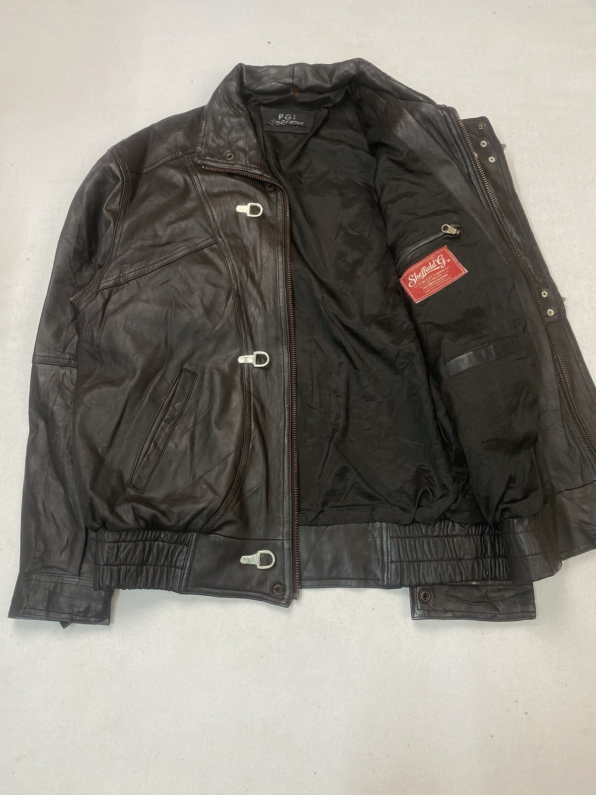 Jacket held open to show the dark inner lining and zipped inside pocket