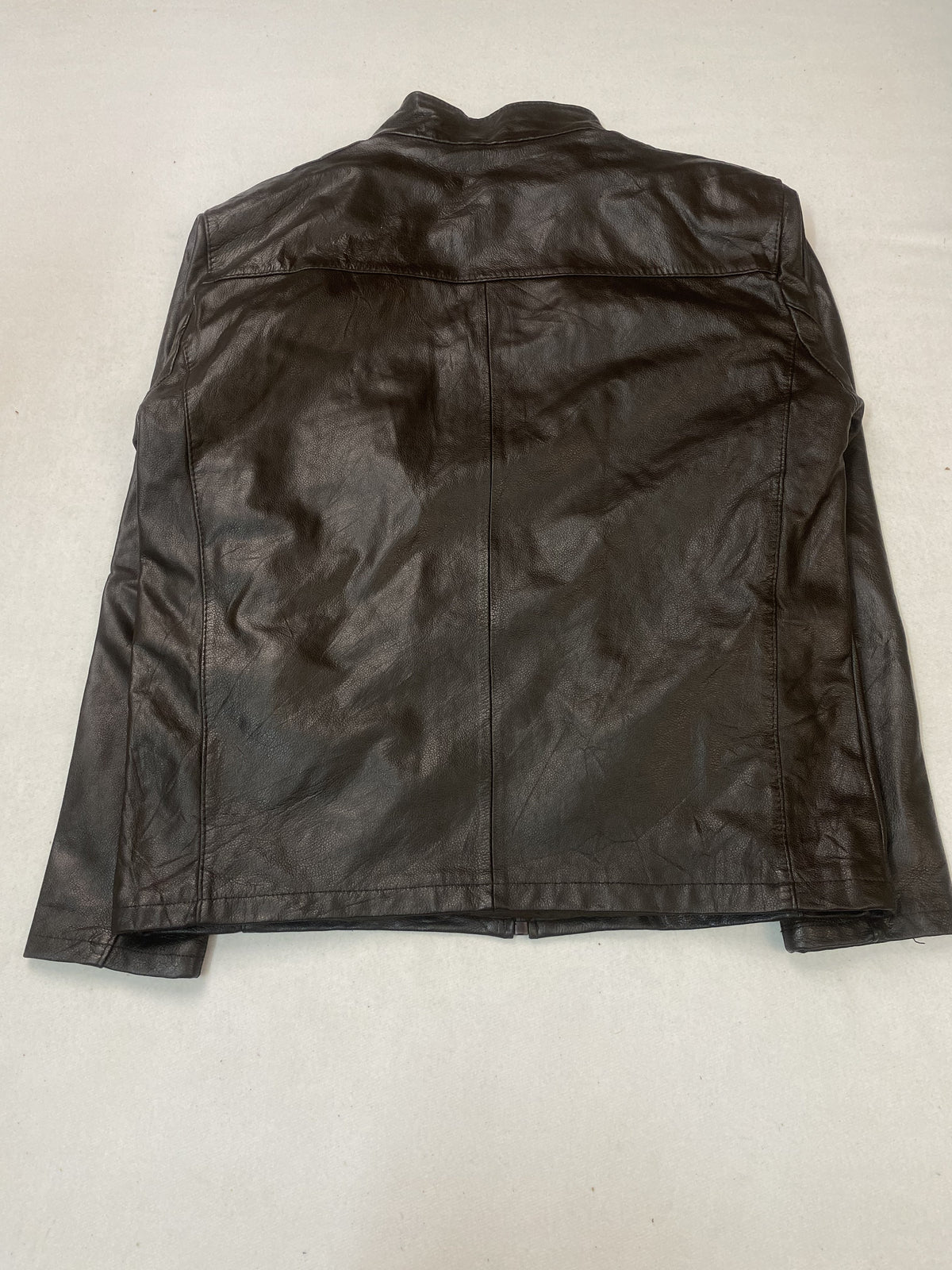 Back of the large cafe racer laid flat, an unbroken leather panel above the hem