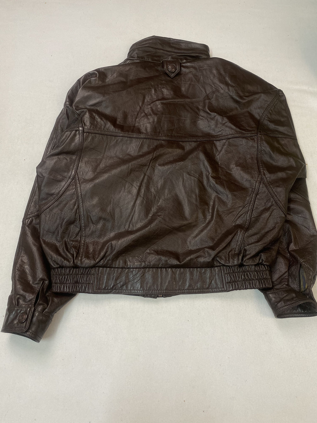 Striped satin lining inside the brown leather harrington