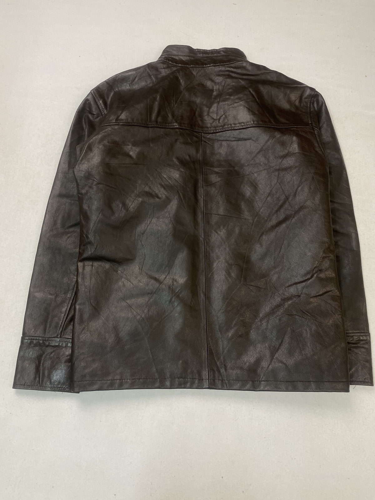 Back of the large cafe racer laid flat, plain leather with a yoke seam at the shoulders