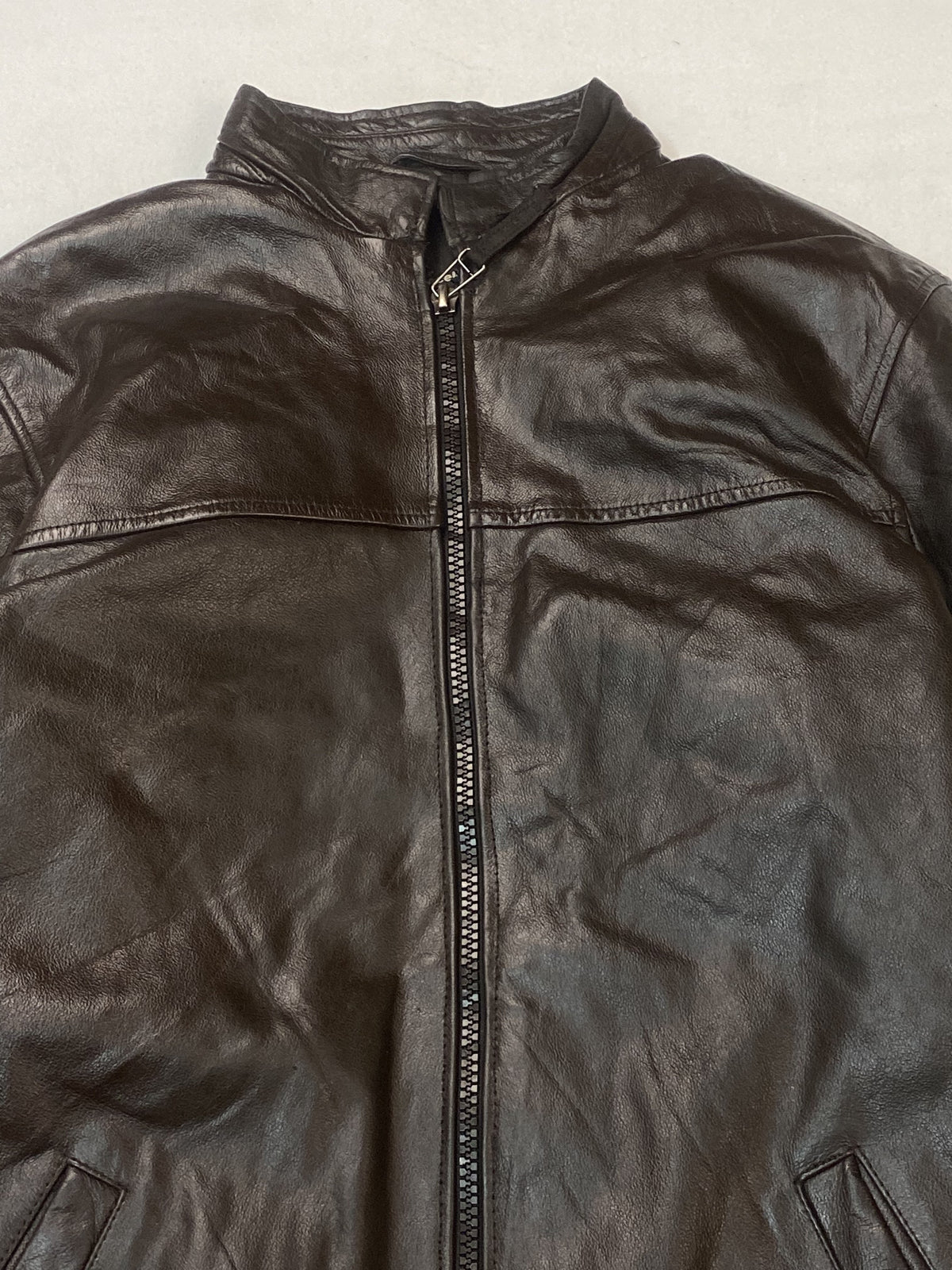 Band collar and the chest seam above the long central zip