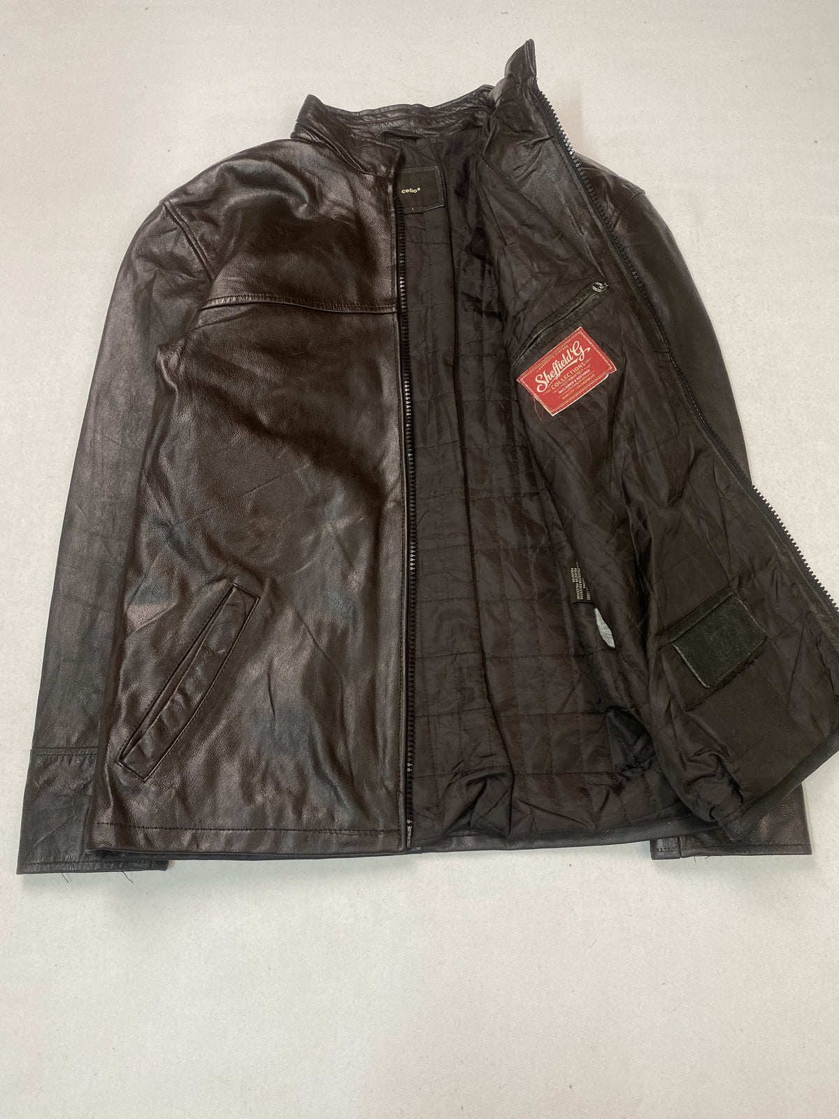 The jacket held open to show the quilted brown lining and an inner pocket