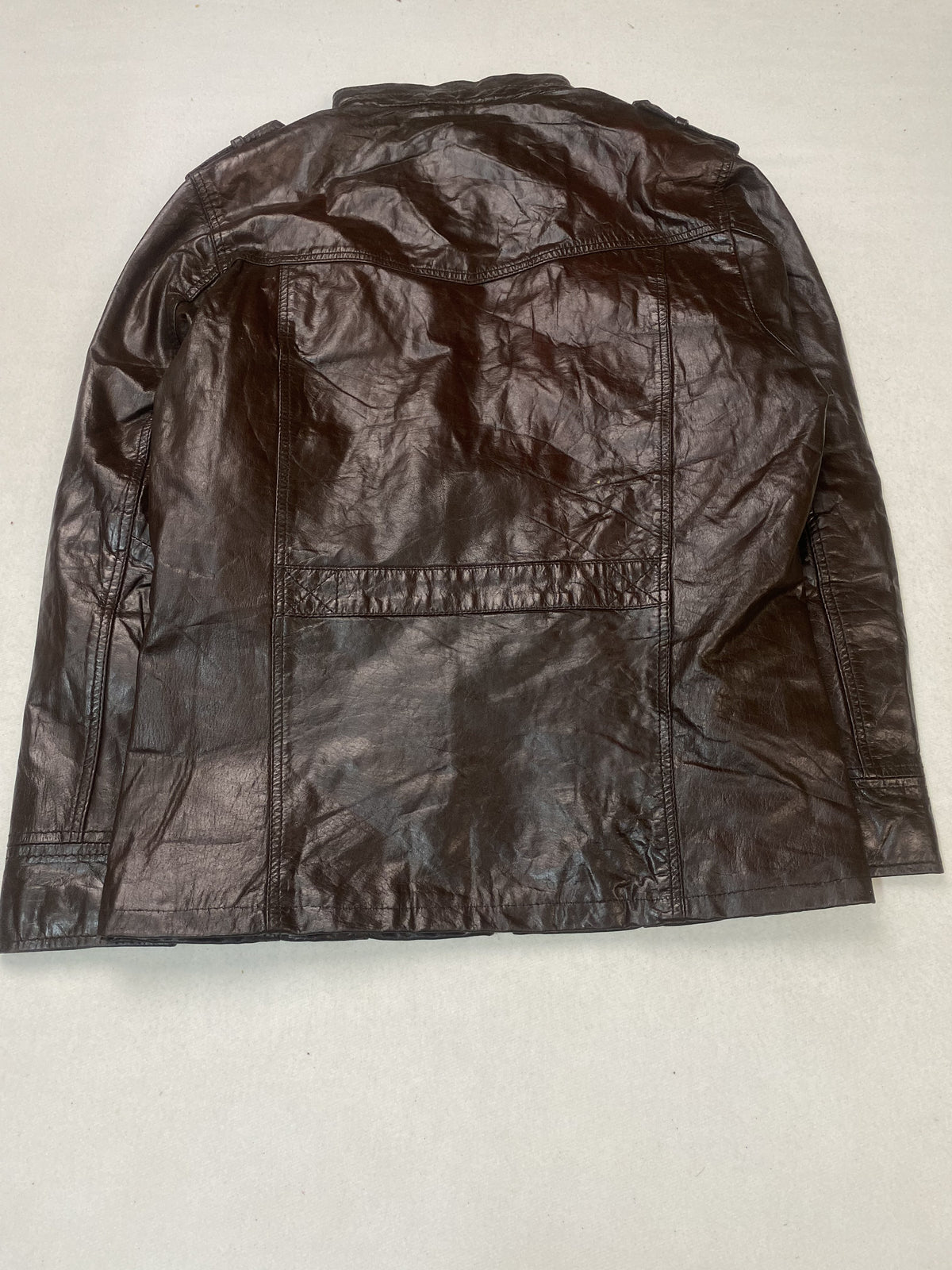 Plaid check lining inside the brown leather trucker jacket
