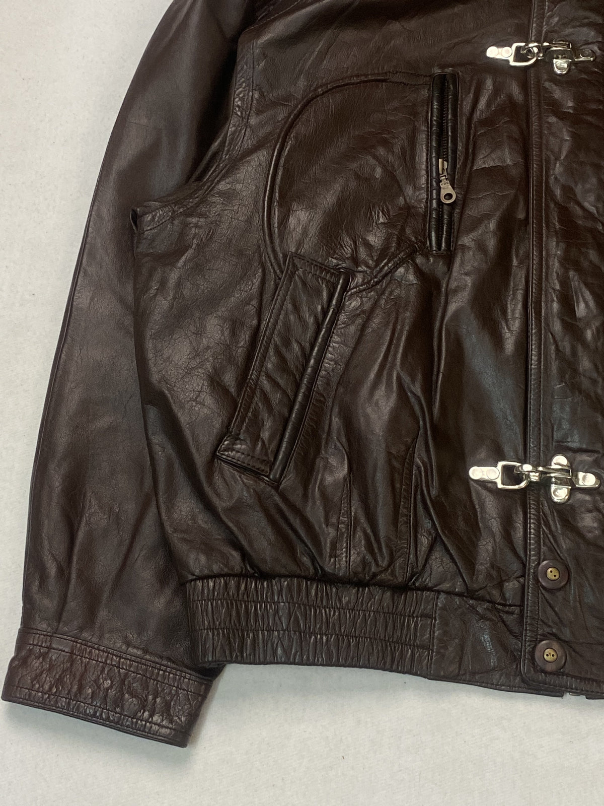 Hook clasp closing the front of the brown leather jacket