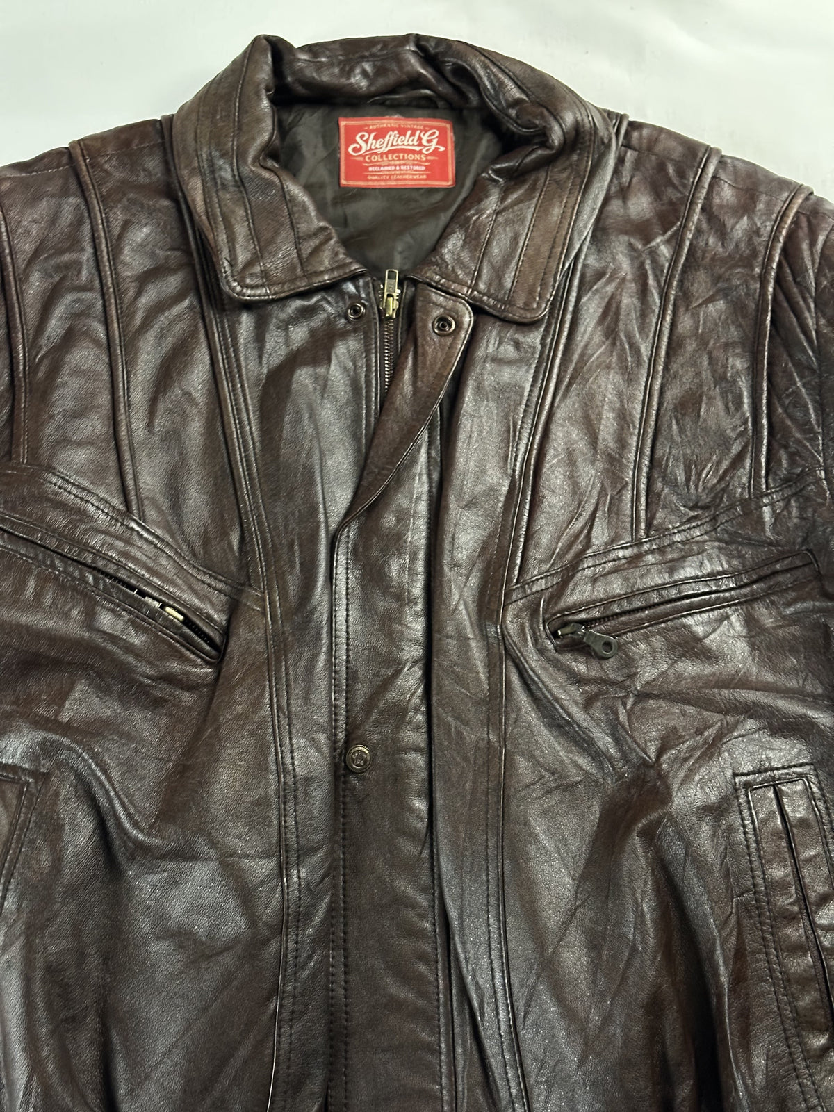 Close view of the point collar, neck label and the stud over the centre zip