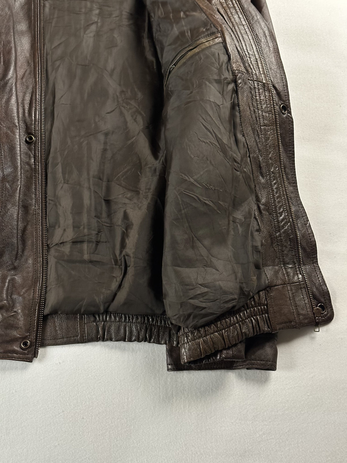 Plain dark lining inside the brown jacket, held open above the elasticated hem