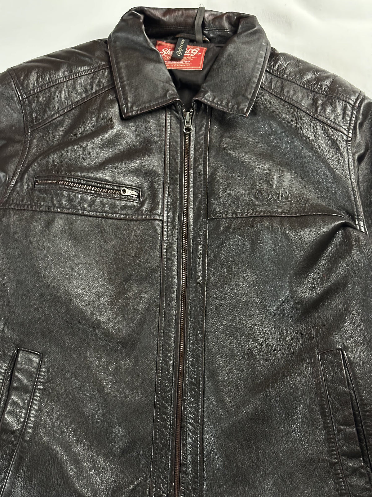 Upper front showing the pointed collar, zip chest pocket and neck label