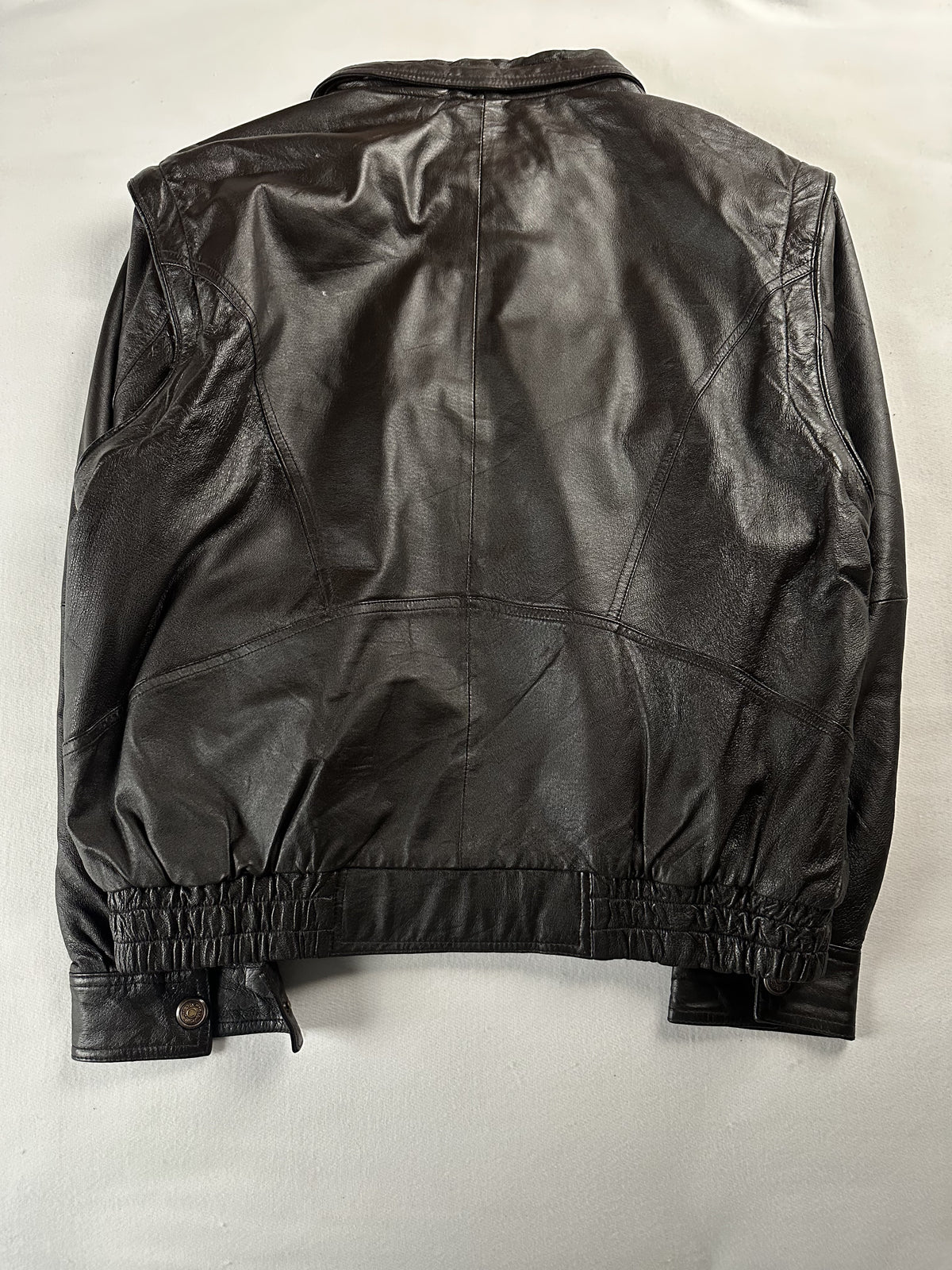 Elasticated waistband gathering the hem of the brown harrington