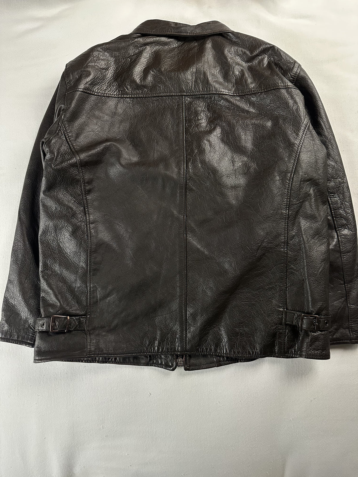 Rear view of the roomy XL brown jacket laid flat with studded tabs at the waist