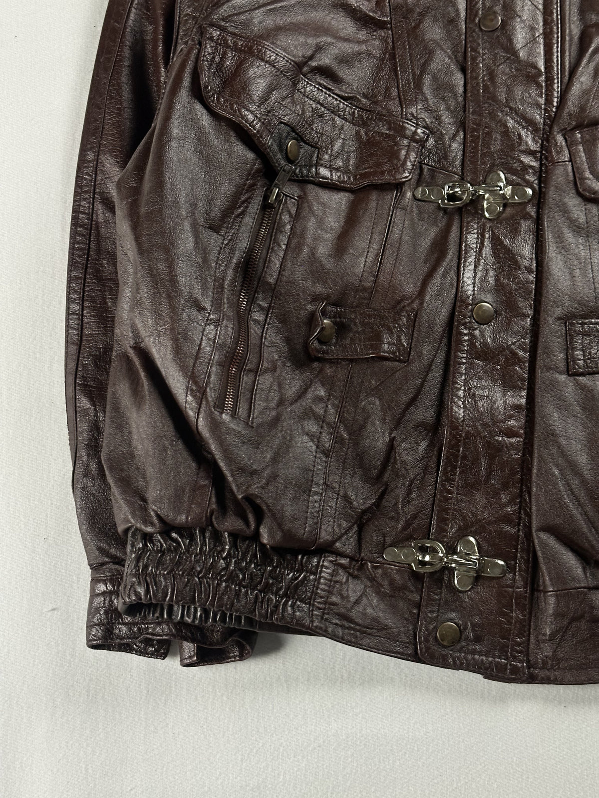 Ornate metal clasp fastening on the brown leather jacket