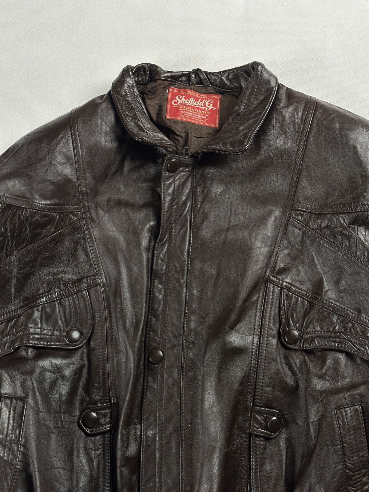 Upper front with the short stand collar and press-stud placket over the zip