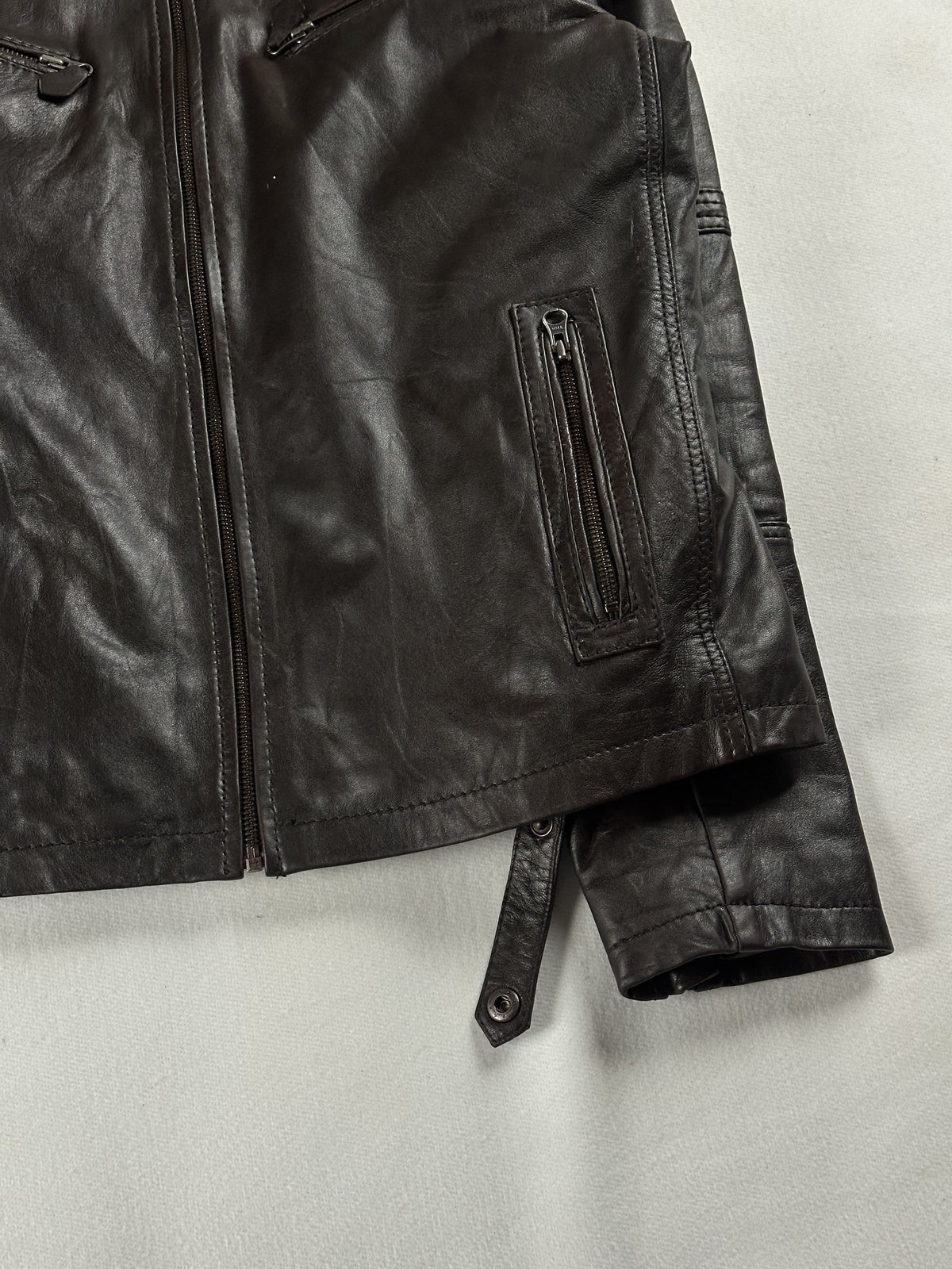 Angled close view of the right hand pocket and the adjuster strap on the cuff