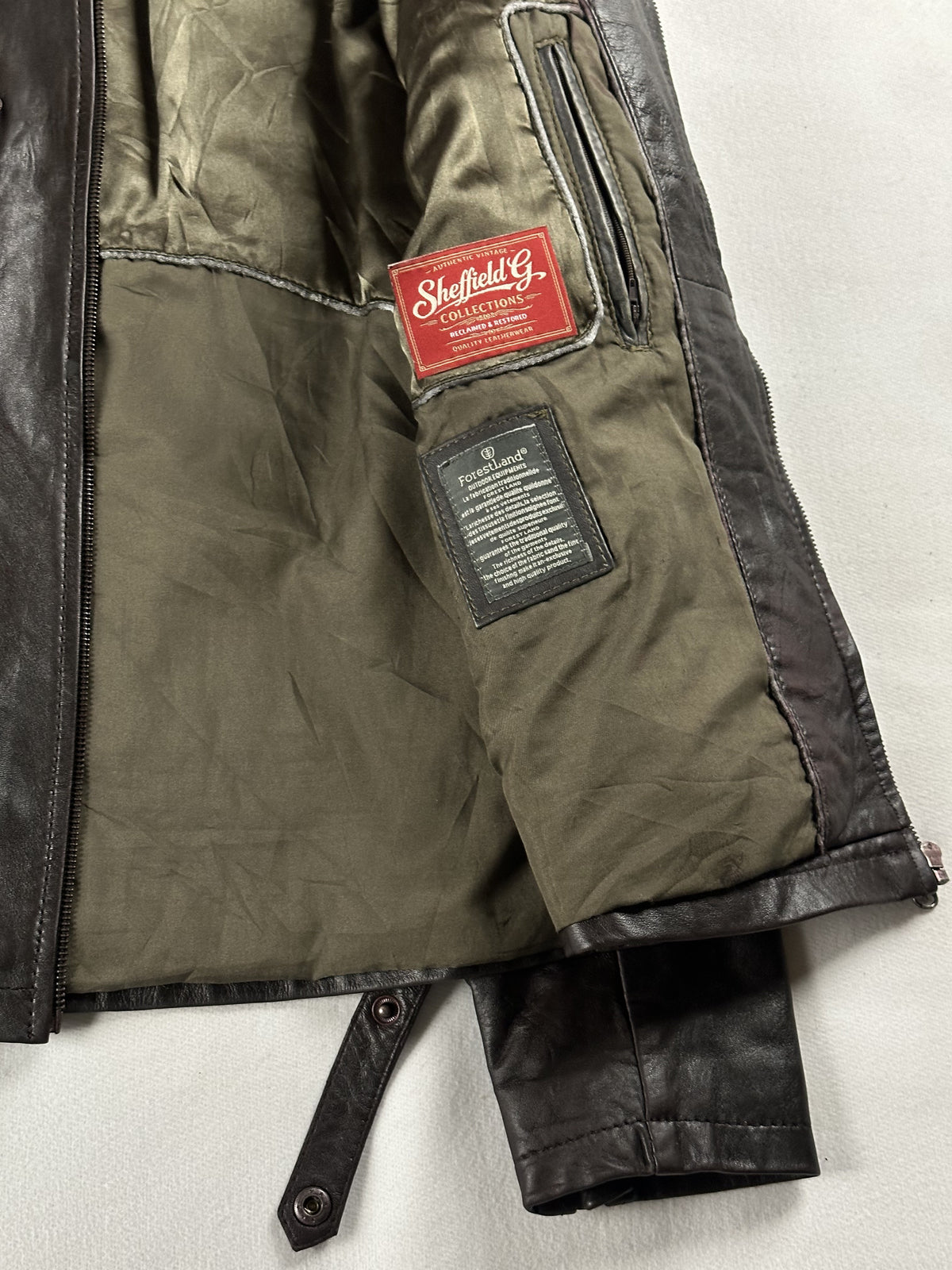 Olive quilted lining held open inside the cafe racer, with the sewn-in care label