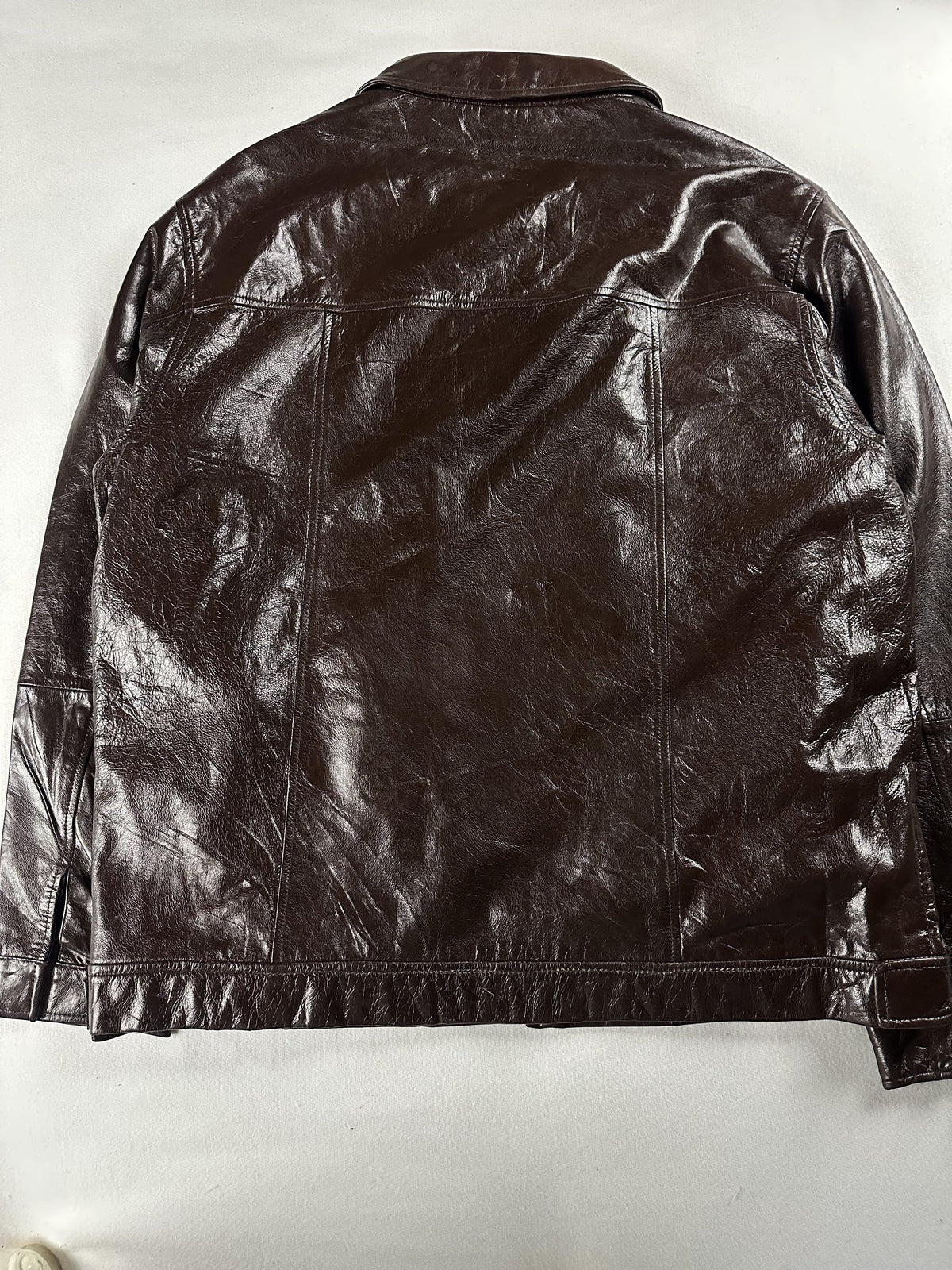 High gloss sheen across the brown leather of the jacket