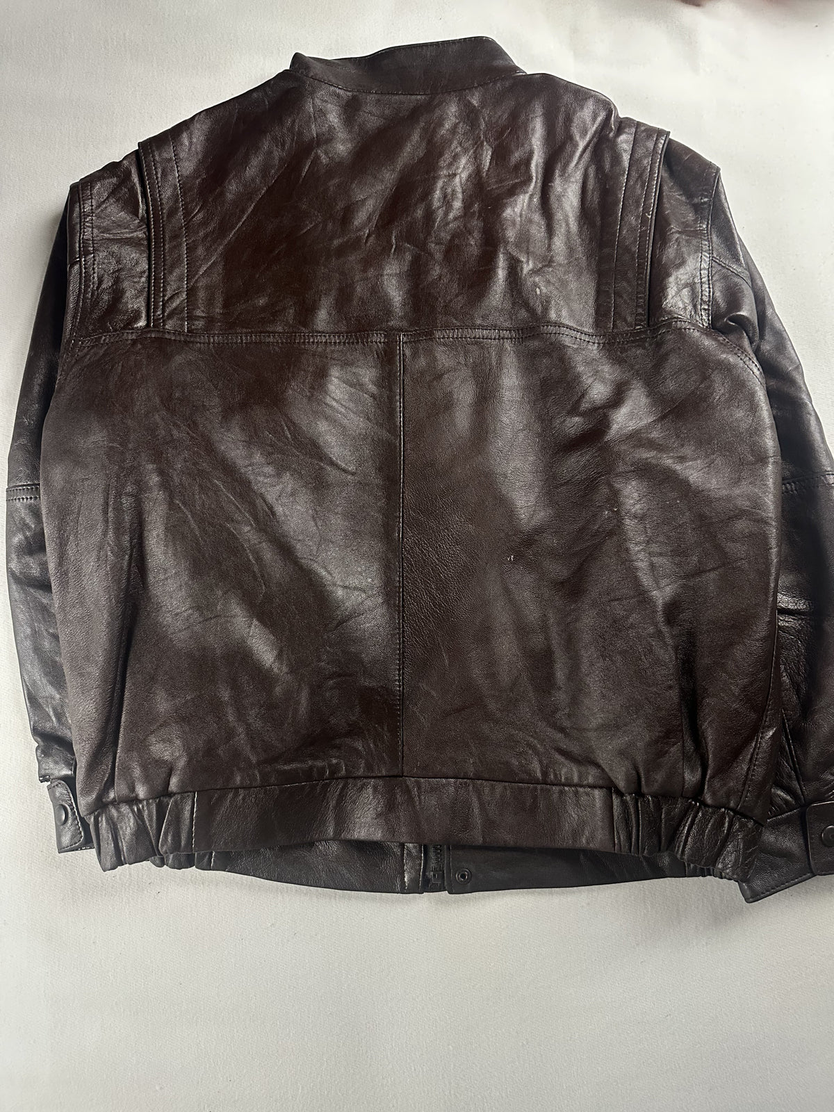 Snap button closing a pocket on the brown leather field jacket