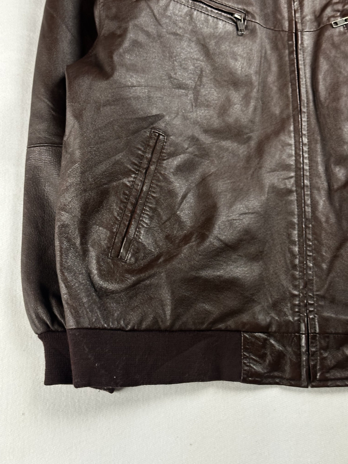 Detail of a slanted welt pocket where the ribbed hem meets the cuff