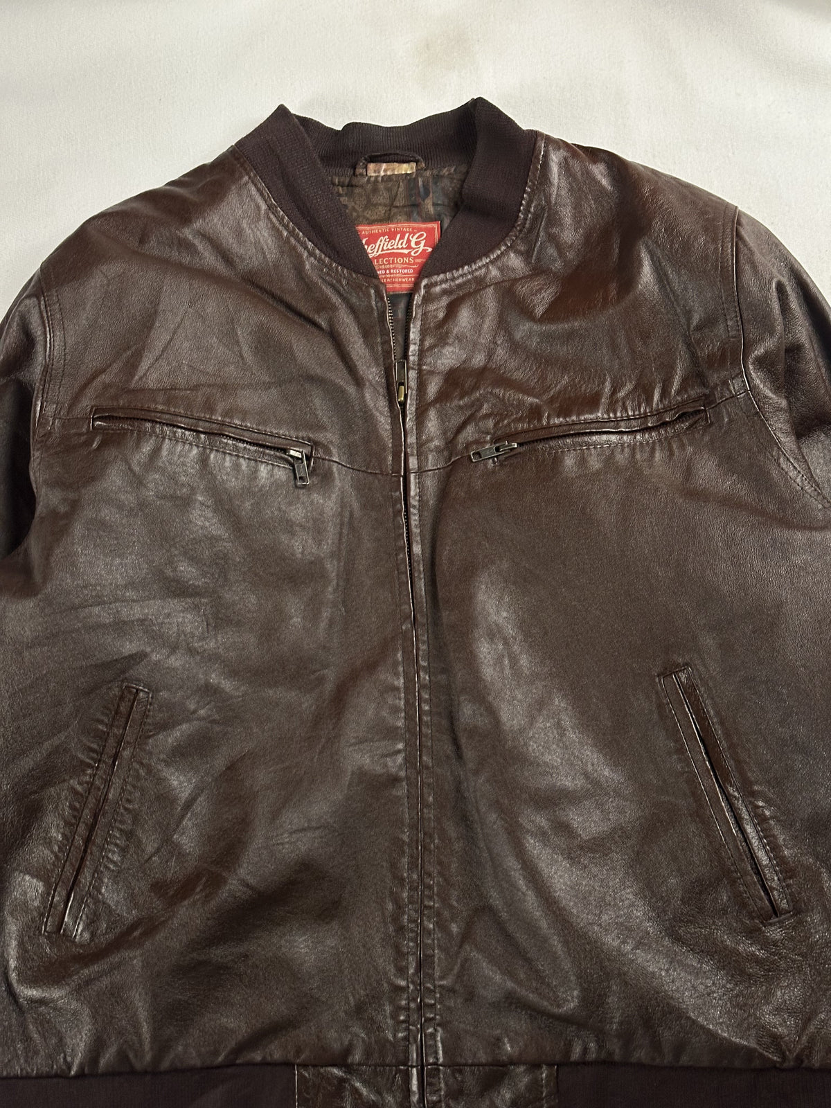 Knitted band collar and the zipped chest pockets at the top of the jacket