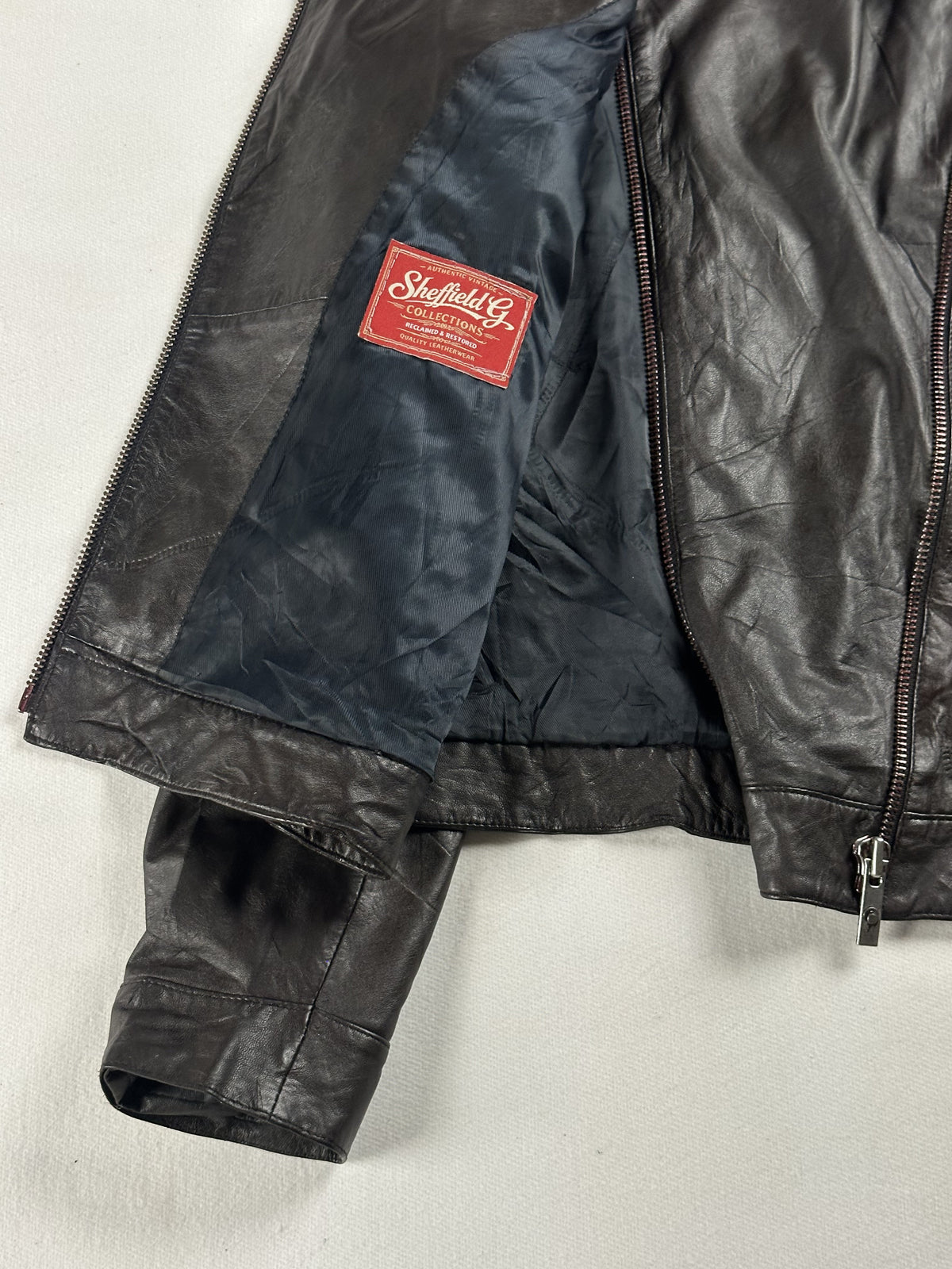 Navy lining held open inside the biker jacket, with its small red woven label