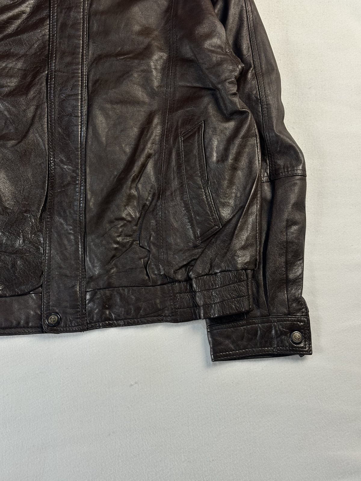 Buttoned cuff and the ribbed hem on the right side of the bomber