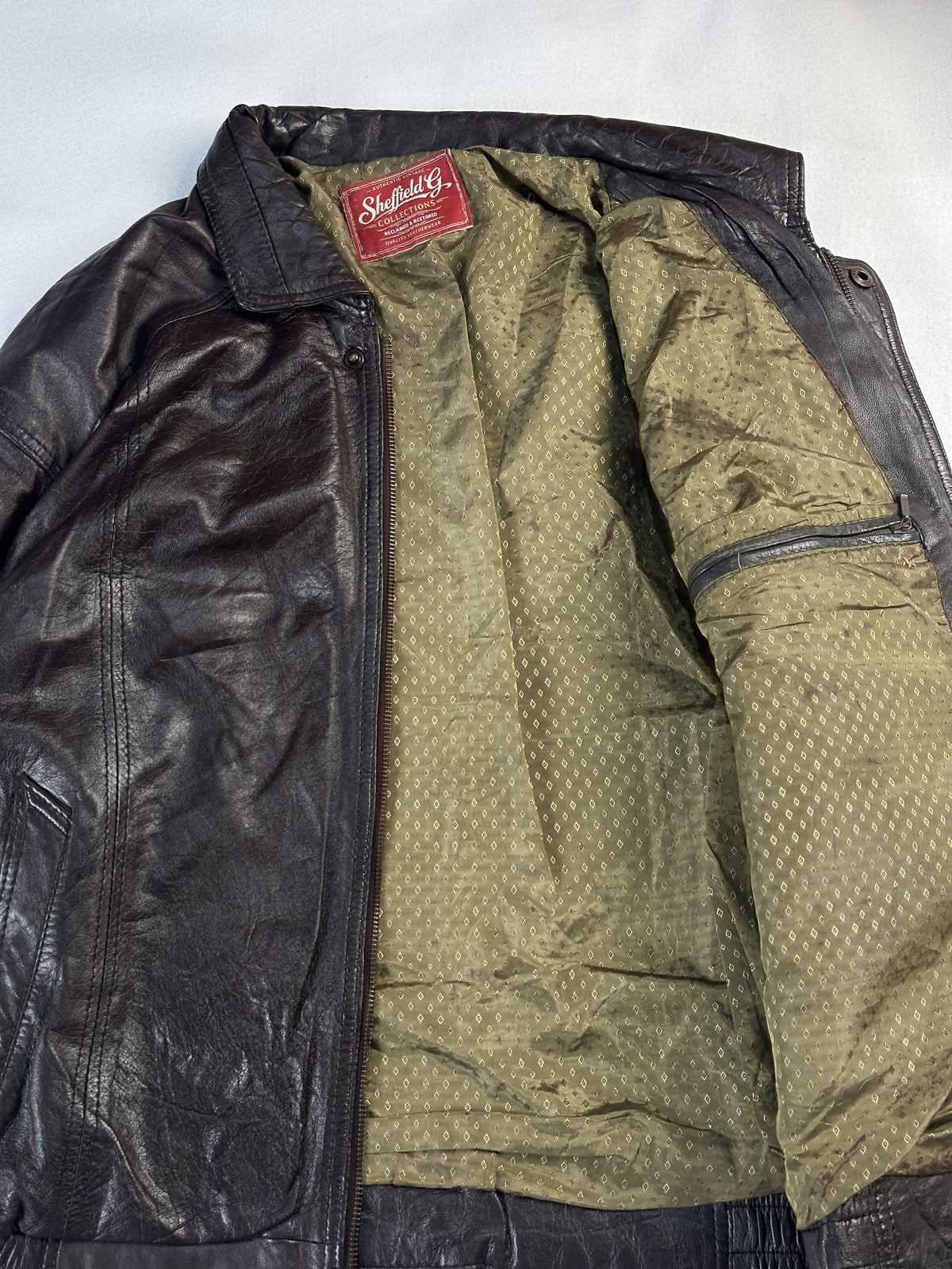 Olive diamond-weave lining inside the bomber with a zipped inner pocket