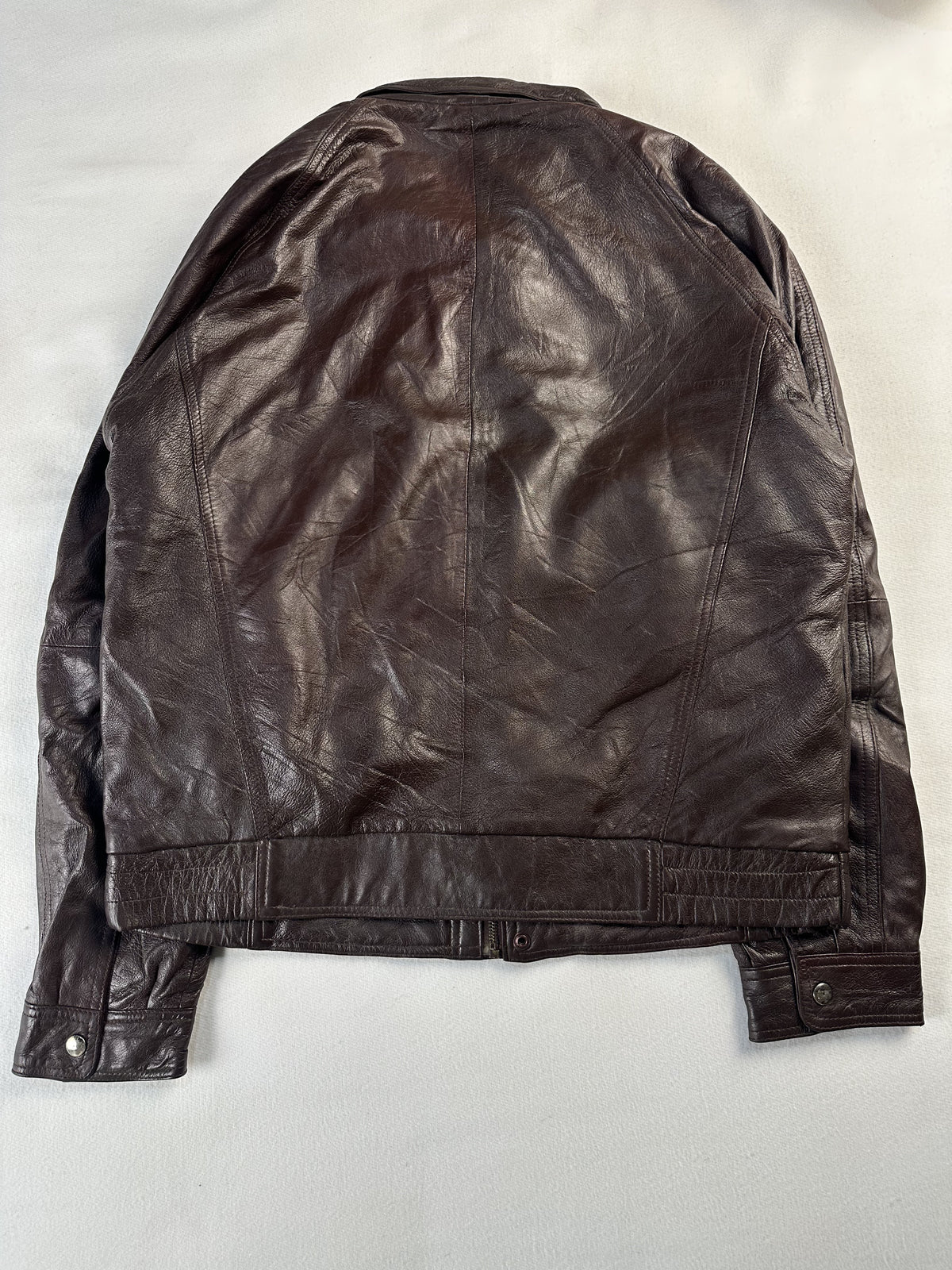 Metal clasp fastening down the front of the brown leather jacket