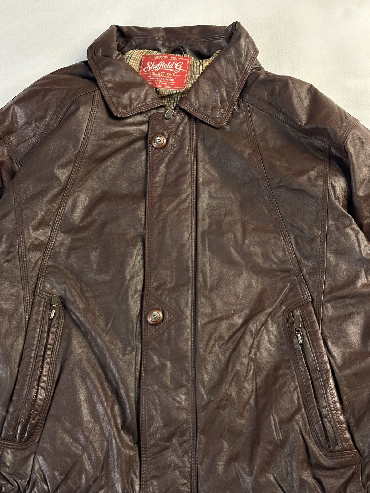 The size XL brown harrington, 25 inches long through the body