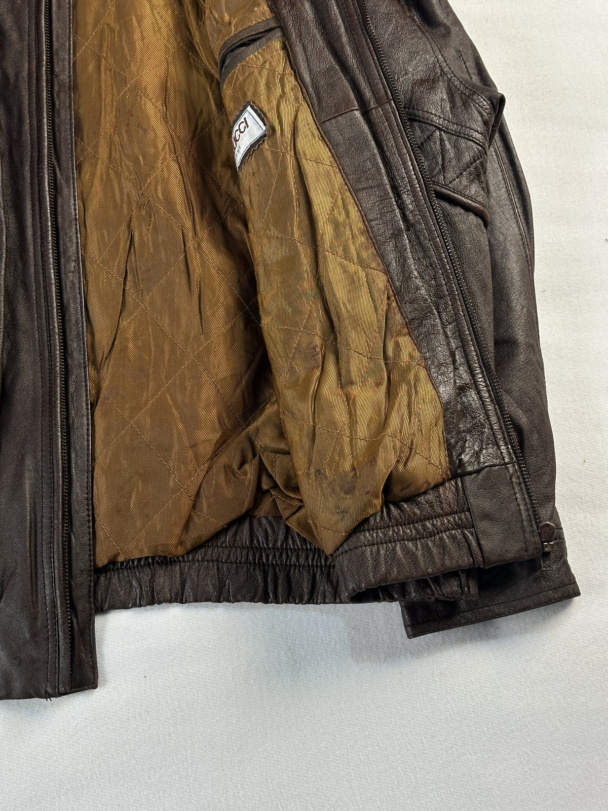 Tan quilted lining with an interior zip pocket inside the brown leather jacket