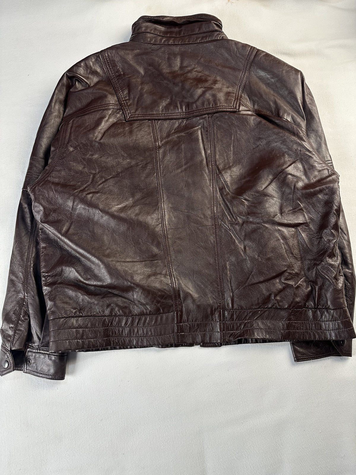 Throat latch fastening at the collar of the brown field jacket