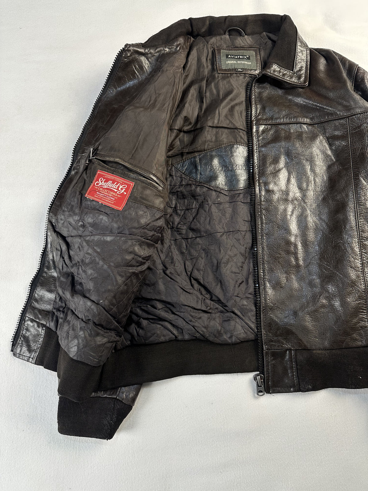 Brown flight jacket held open to show the full lining and inner chest pocket